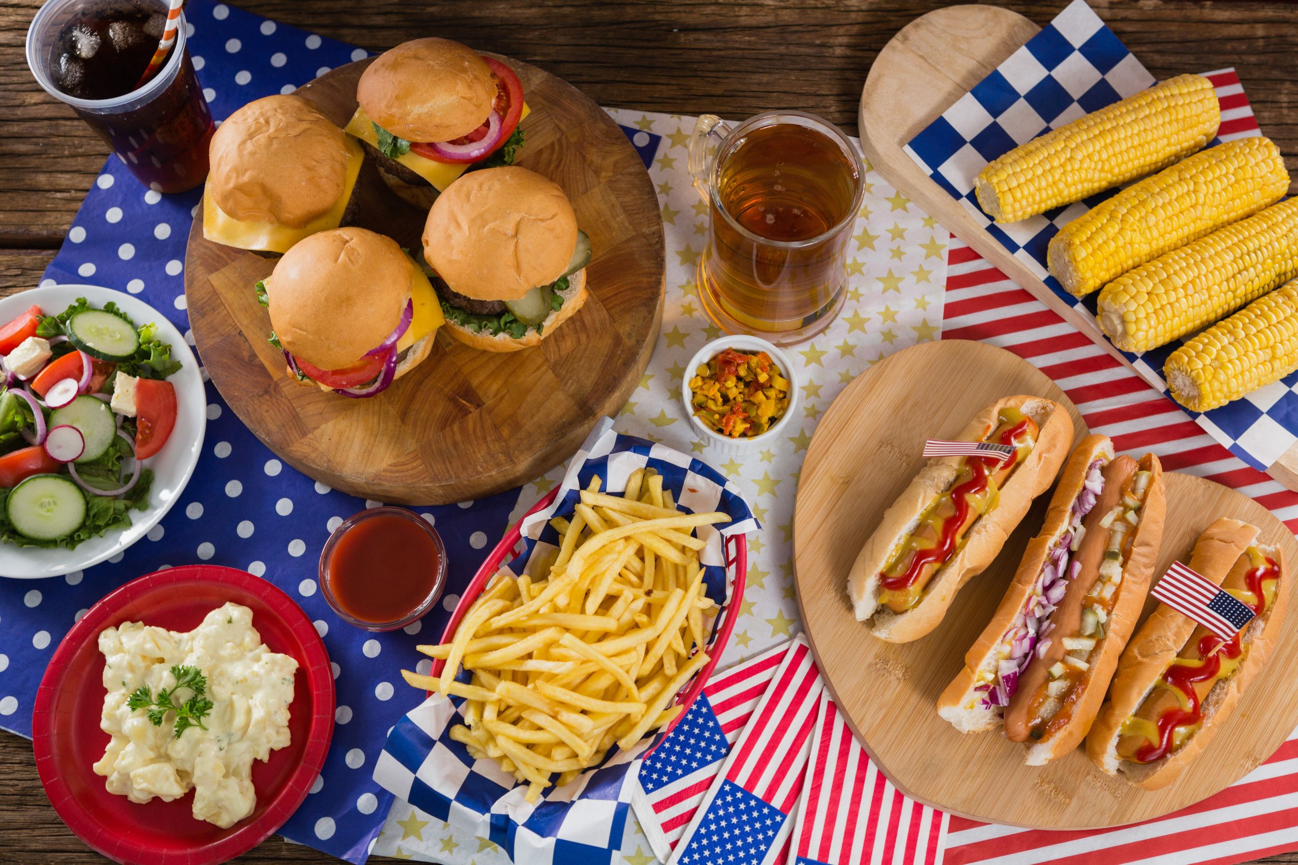 4Th Of July Hot Dogs
 Close up of hot dogs and burgers on wooden table with 4th