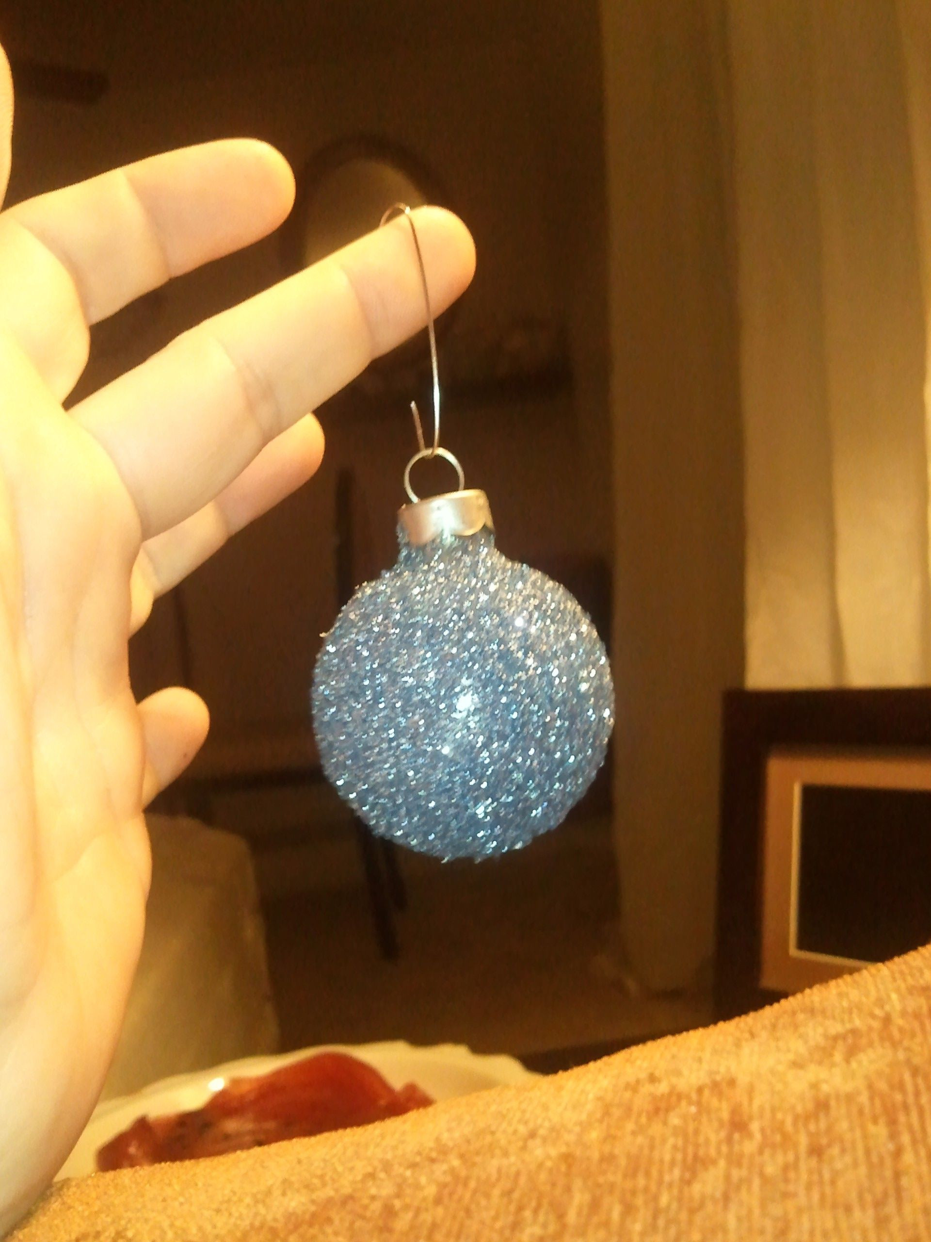 DIY Glitter Ornaments With Hairspray
 glittered ball ornaments made by sprinkling glitter on
