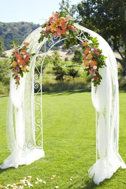 How To Decorate A Wedding Arch With Fabric
 A golf course wedding arch with tulle draping and orange
