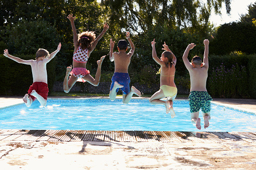 Kids Outdoor Swimming Pool
 Rear View Children Jumping Into Outdoor Swimming Pool